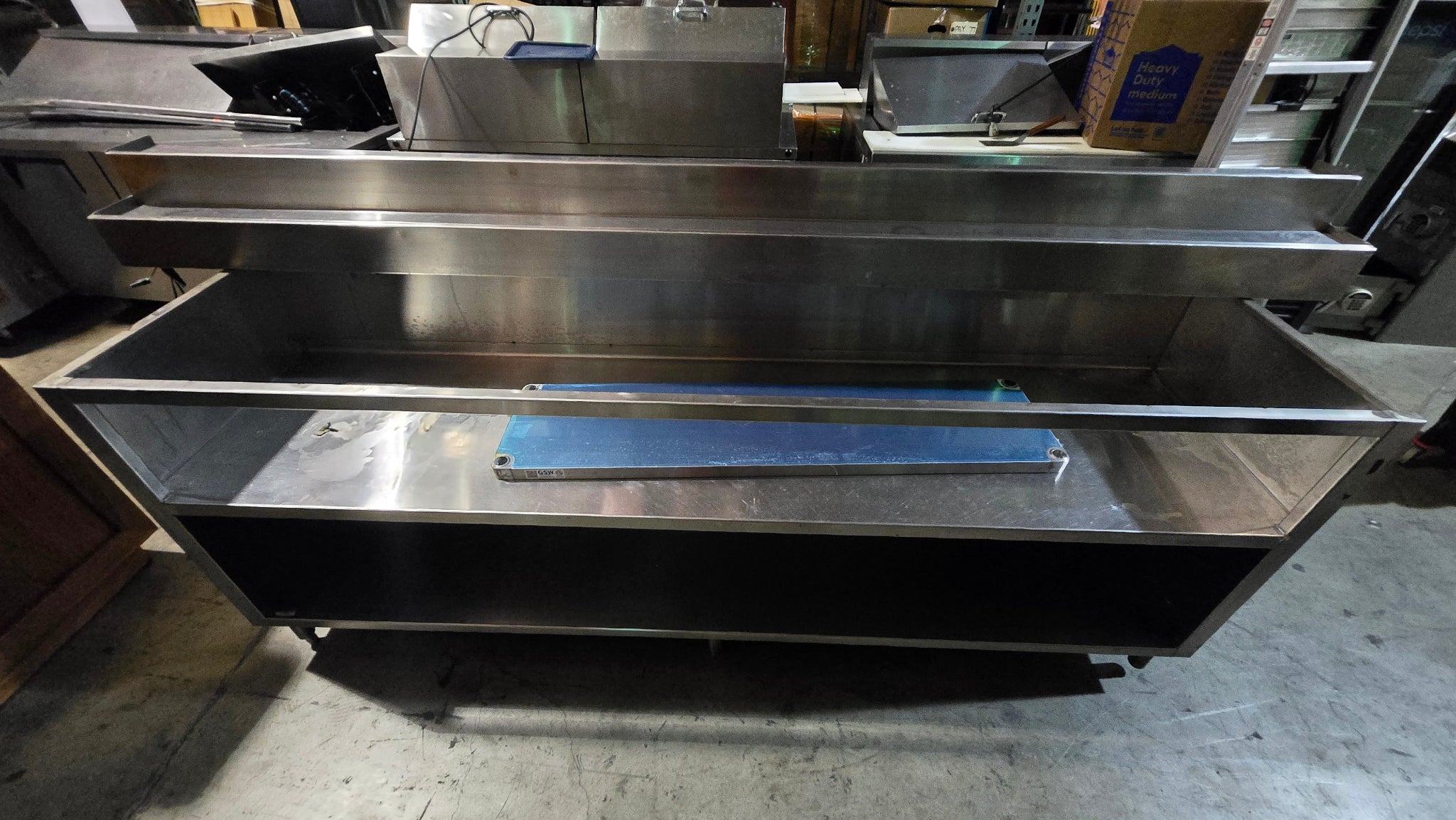 Commercial-grade Stainless Steel Service Counter With An Detached Upper Shelving Unit.