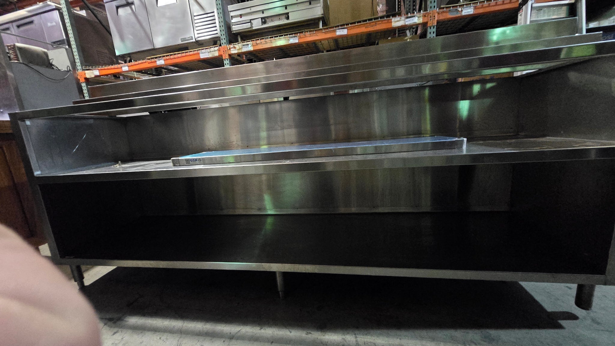 Commercial-grade Stainless Steel Service Counter With An Detached Upper Shelving Unit.